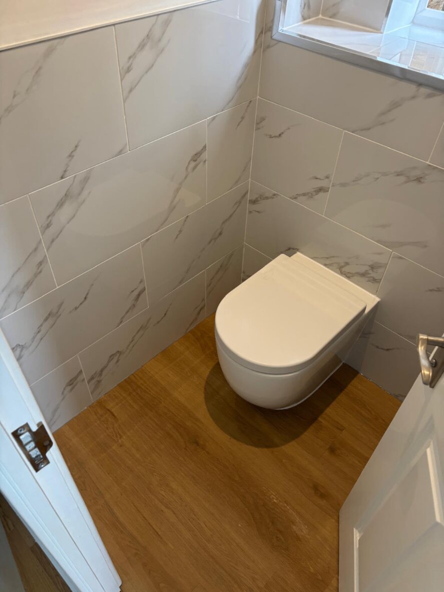 Cloakroom toilet and marble-effect tiling fitted by Plumb4You